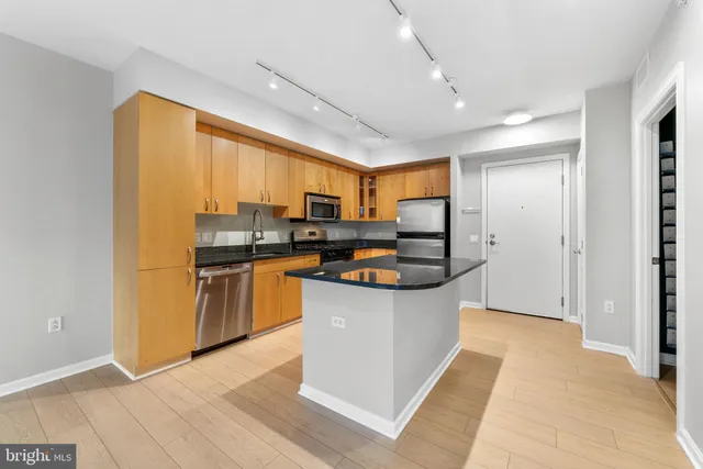 a kitchen with stainless steel appliances granite countertop a refrigerator a sink a stove and oven