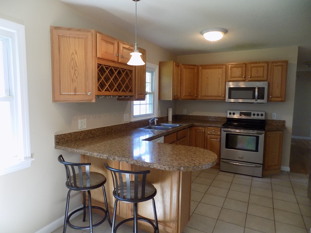 90 Embassy Road Springfield, MA 01119 - Photo 2 of 18 a kitchen with kitchen island granite countertop a stove a sink and a microwave