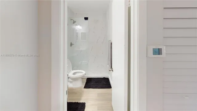 a bathroom with a granite countertop toilet a sink and a shower
