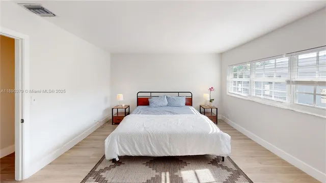 a bedroom with a bed and a large window