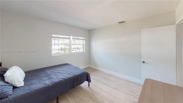 a spacious bedroom with a bed and a window