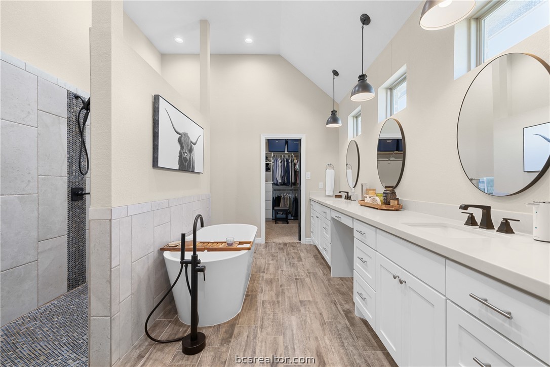 3222 Hunters Crossing Bryan, TX 77808 - Photo 22 of 44 Full bath with double vanity, a spacious closet, light wood-style flooring, a walk in shower, and a soaking tub