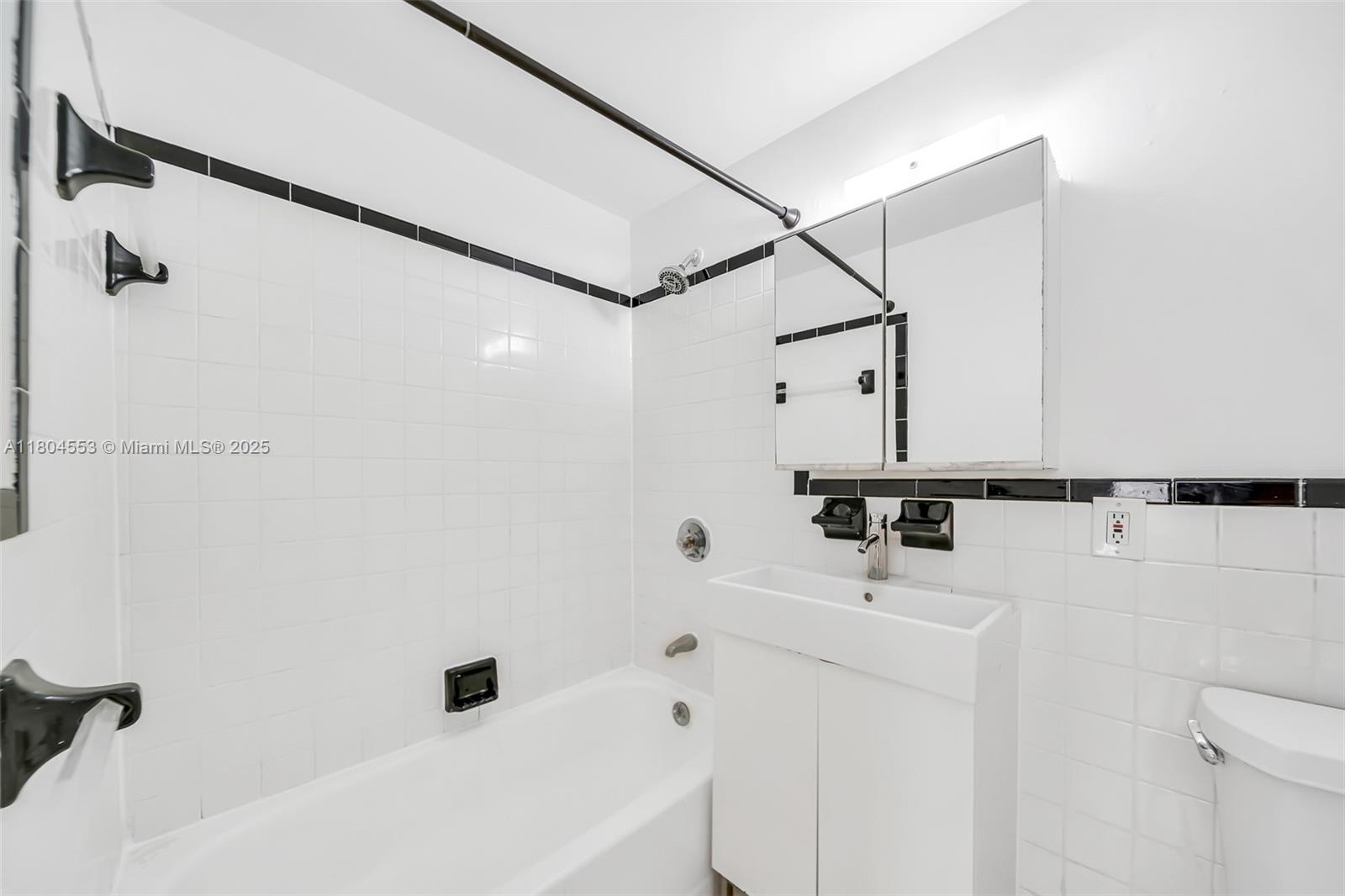 1051 Meridian Avenue, Unit 1D Miami Beach, FL 33139 - Photo 11 of 16 a bathroom with a sink a toilet and a tub