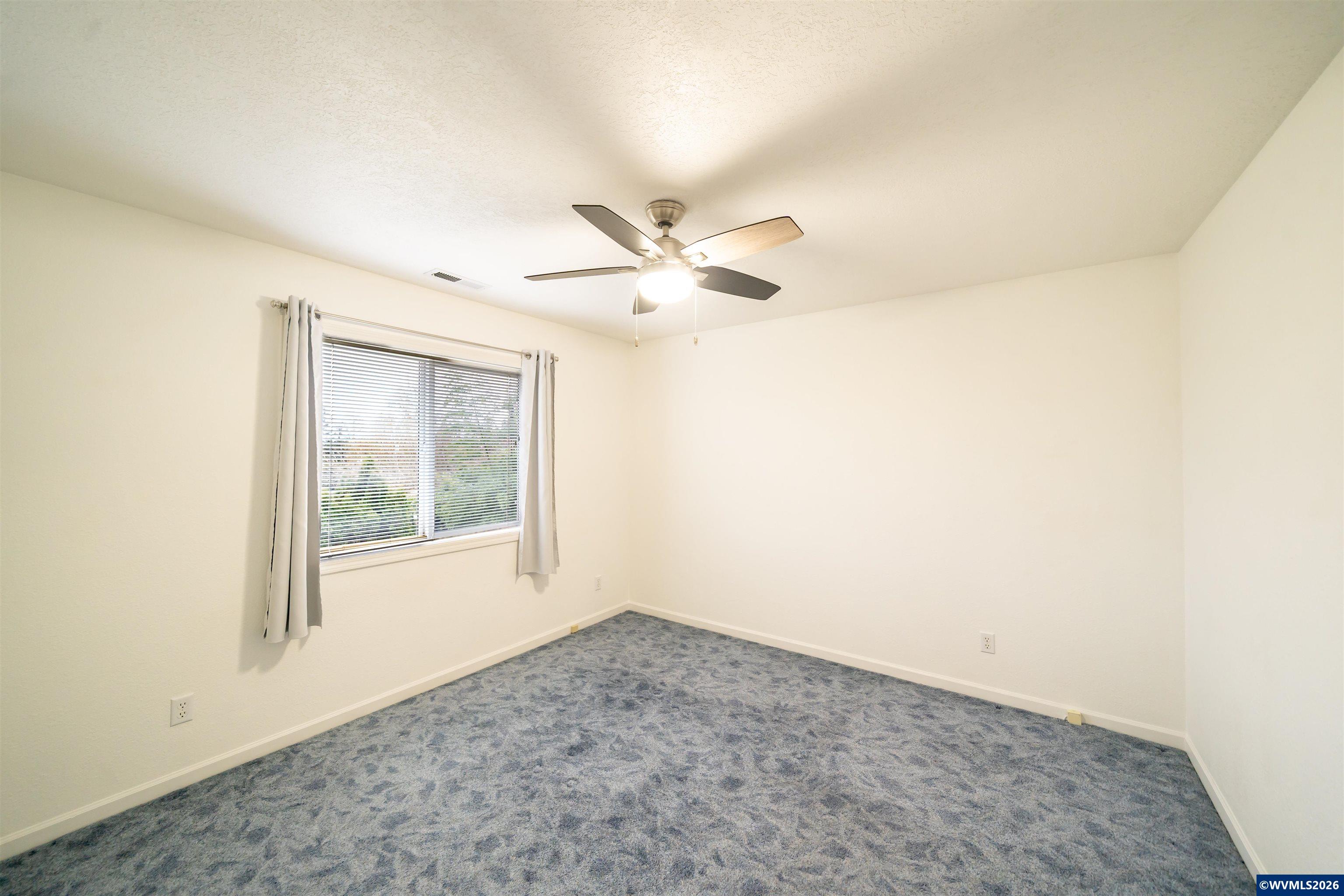 312 Southwest Cascade Meadow Drive Sublimity, OR 97385 - Photo 20 of 42 an empty room with windows and ceiling fan