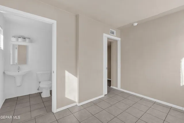 an empty room with a bathroom and mirror