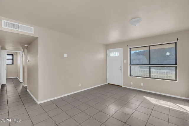 an empty room with entrance and windows