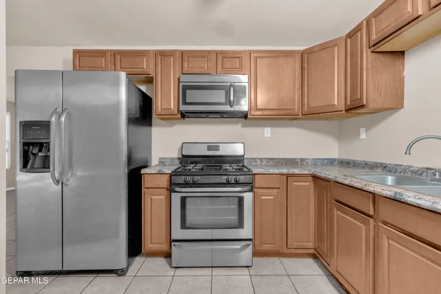 a kitchen with stainless steel appliances granite countertop a stove microwave and refrigerator