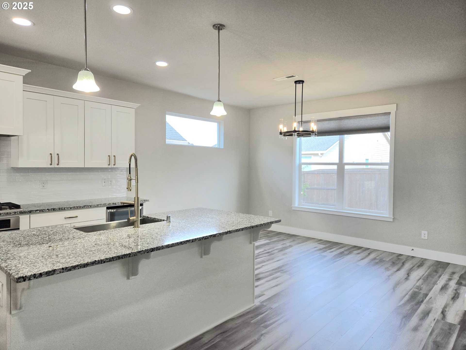 8524 North 1st Street Ridgefield, WA 98642 - Photo 18 of 48 a kitchen with stainless steel appliances granite countertop a sink a window and wooden floor