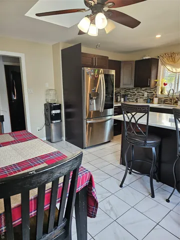 a kitchen with stainless steel appliances kitchen island granite countertop a sink refrigerator and cabinets