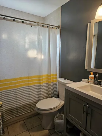 a bathroom with a sink a toilet and shower curtain