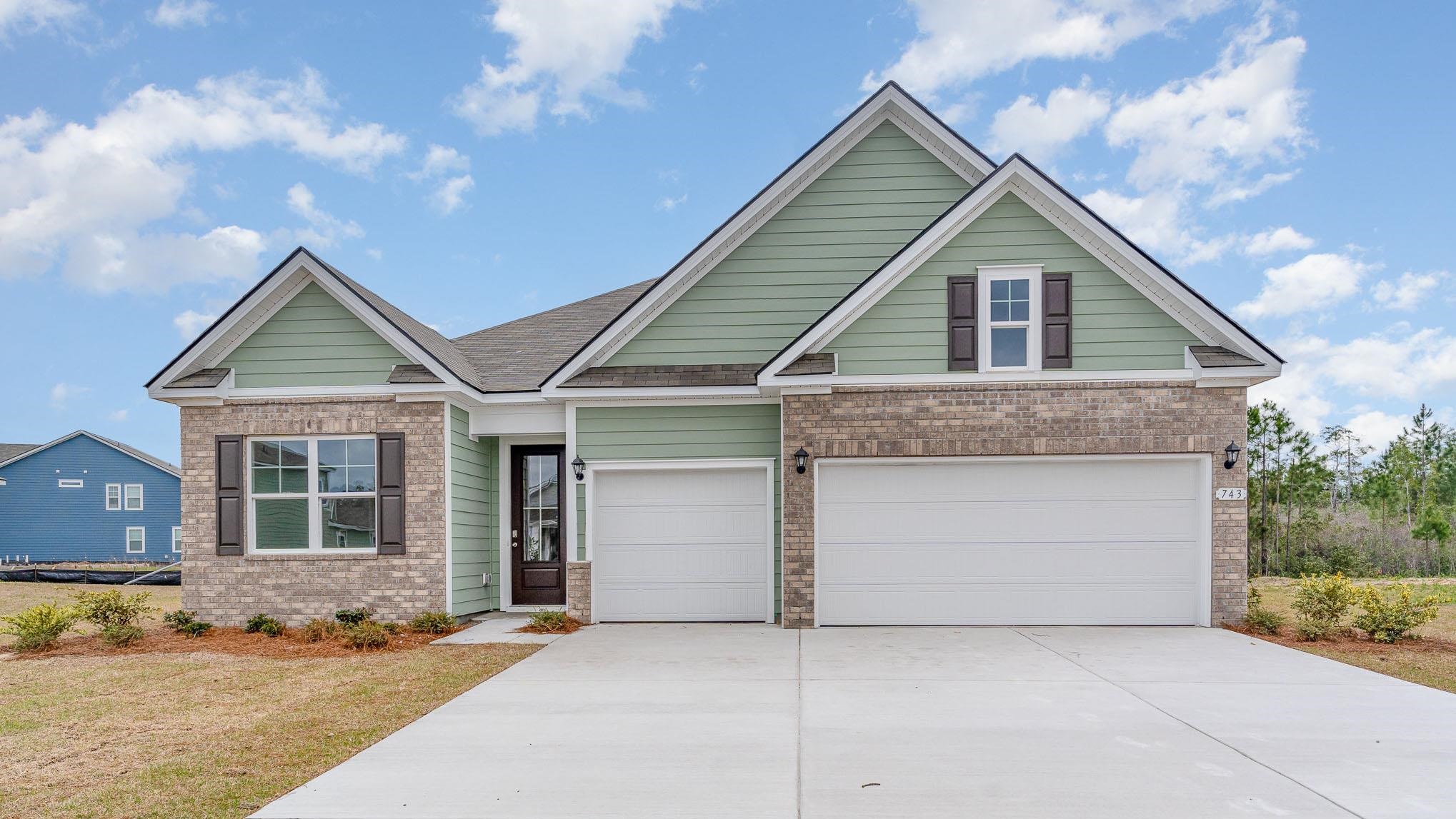 Craftsman-style house with brick siding, concrete driveway, and a front lawn