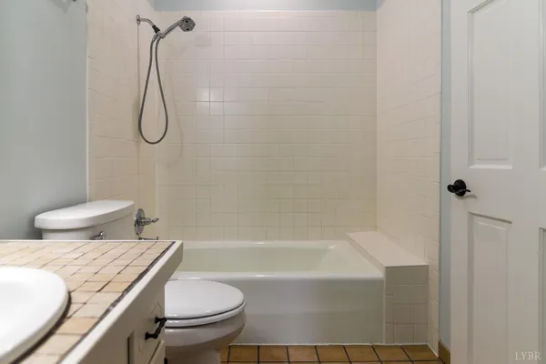 a bathroom with a granite countertop toilet and a shower
