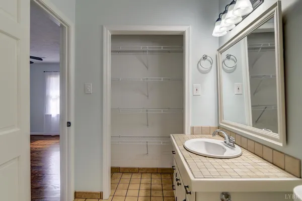 a bathroom with a granite countertop sink a mirror and a shower