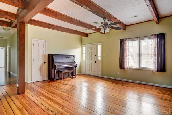 a area with wooden floor and windows
