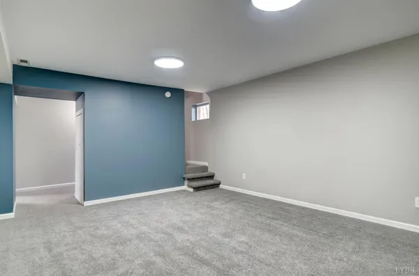 a view of a house with a yard and large tree