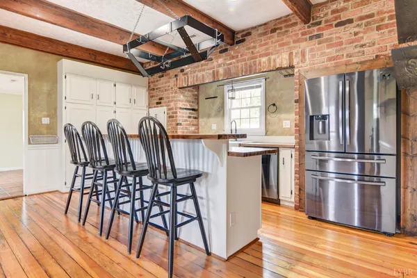 a kitchen with granite countertop a refrigerator and wooden floor