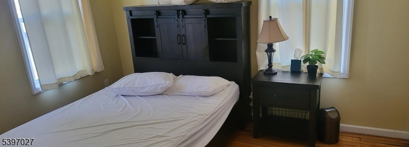 1371 Clinton Avenue Irvington, NJ 07111 - Photo 13 of 41 a bedroom with a bed table and a potted plant