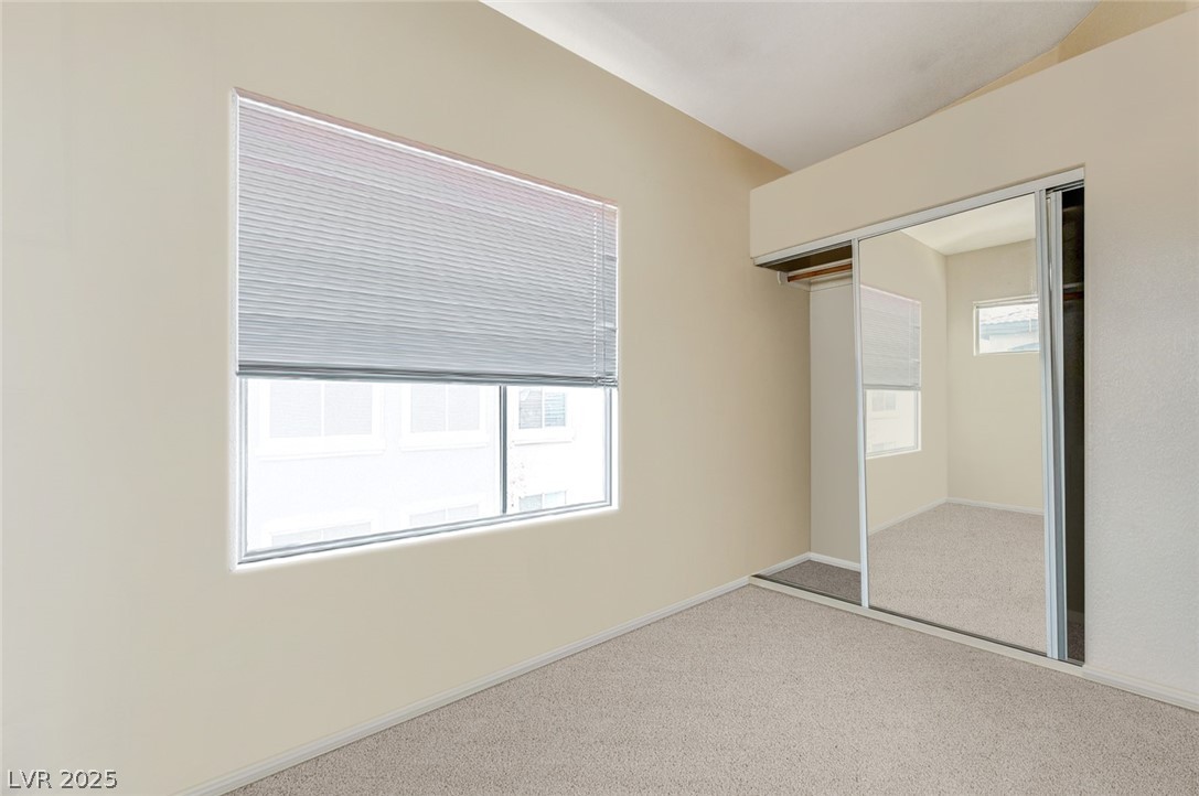 2305 West Horizon Ridge Parkway, Unit 1223 Henderson, NV 89052 - Photo 26 of 28 Unfurnished bedroom with light colored carpet, a closet, and vaulted ceiling