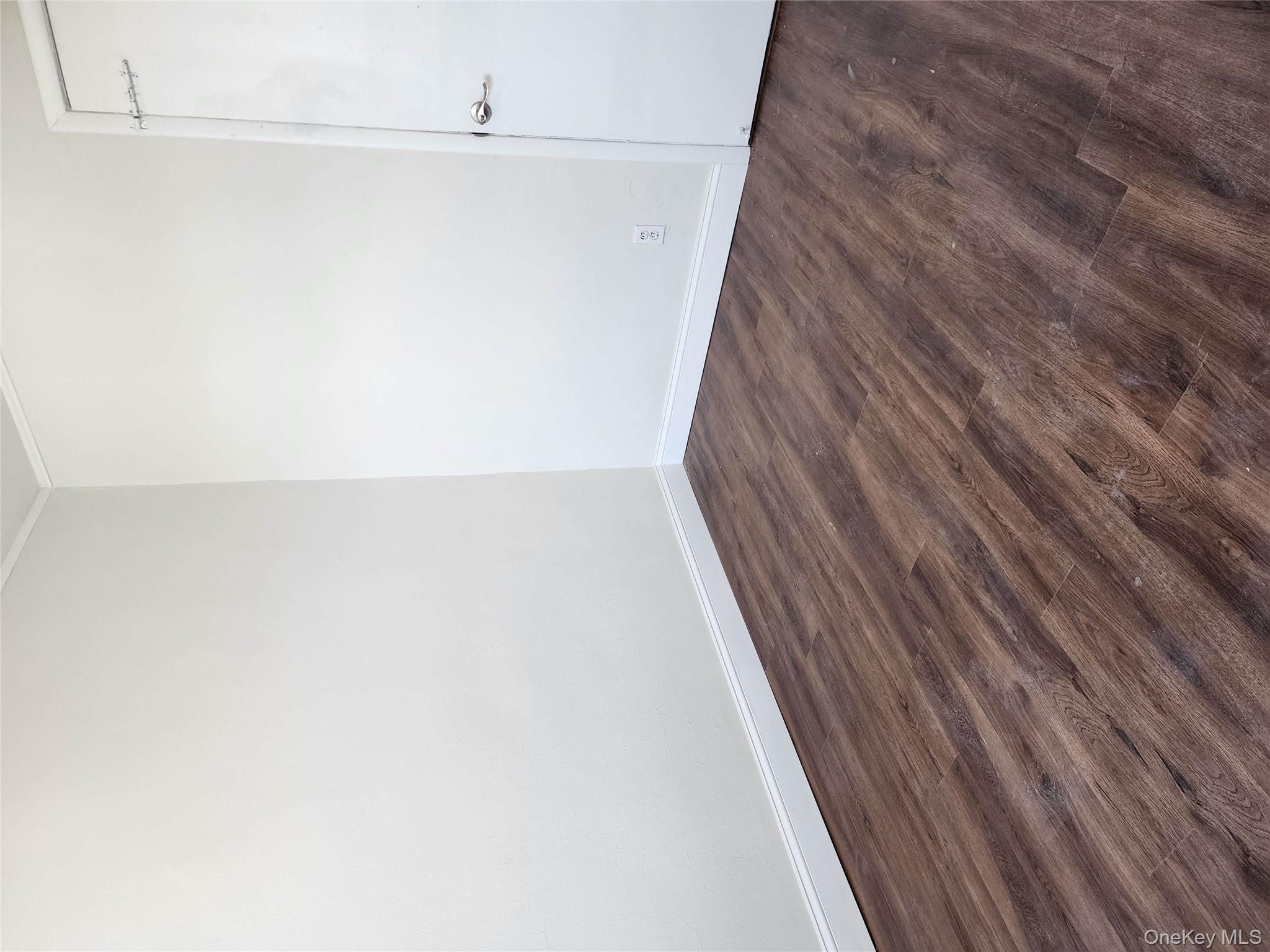 64-10 Myrtle Avenue Queens, NY 11385 - Photo 13 of 15 a view of an empty room with wooden floor