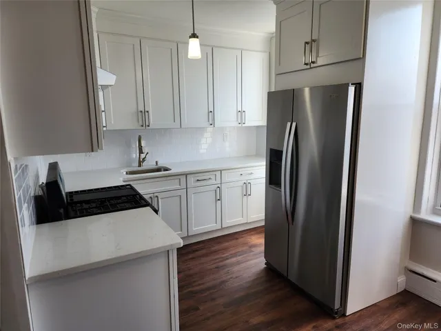 a kitchen with white cabinets and stainless steel appliances