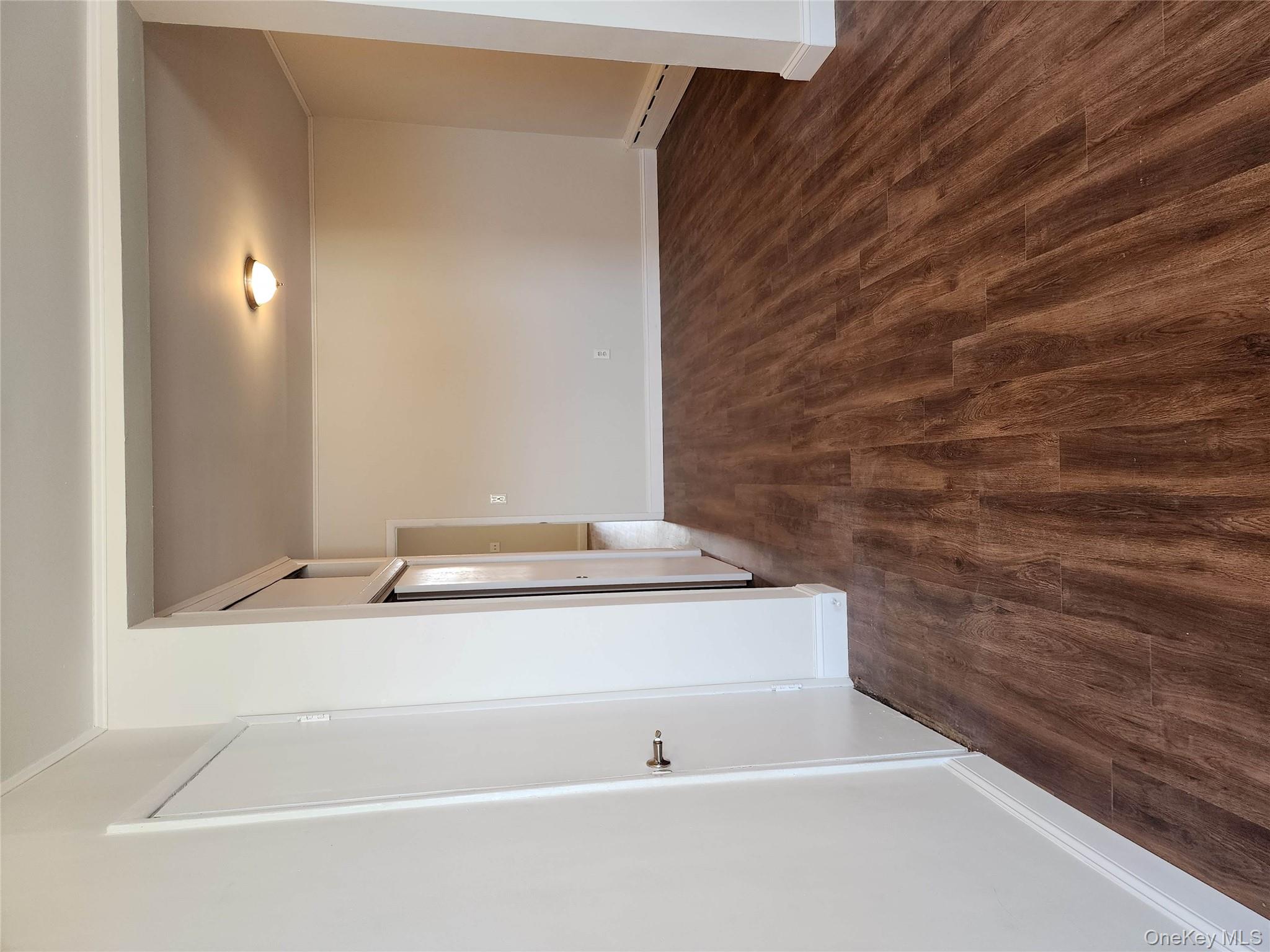 64-10 Myrtle Avenue Queens, NY 11385 - Photo 9 of 15 a view of a room with wooden floor and stairs