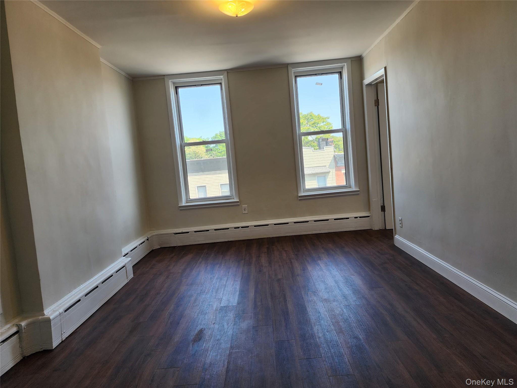 64-10 Myrtle Avenue Queens, NY 11385 - Photo 10 of 15 an empty room with wooden floor and windows