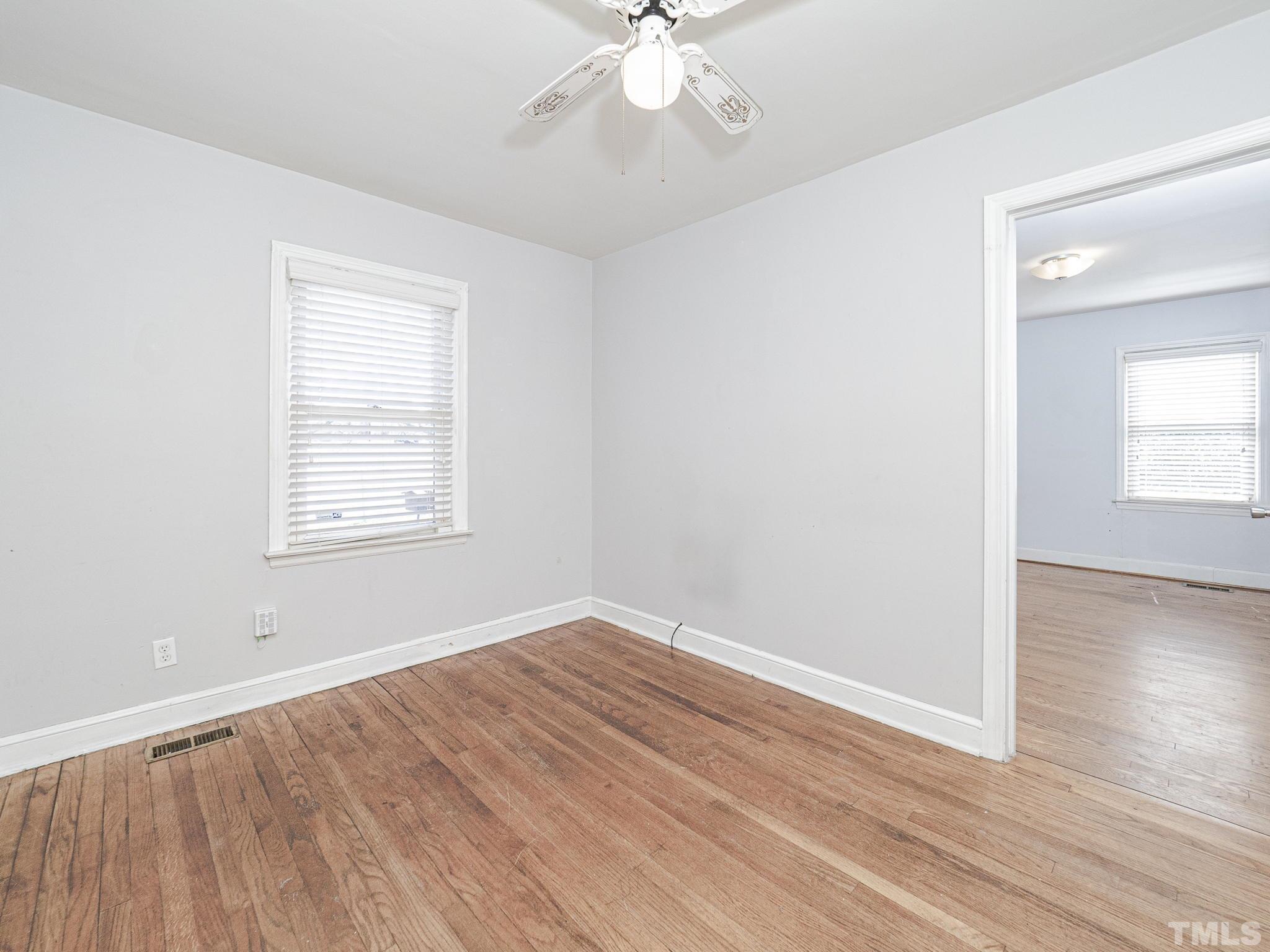 716 Hamilton Road Raleigh, NC 27604 - Photo 4 of 15 an empty room with wooden floor chandelier fan and windows