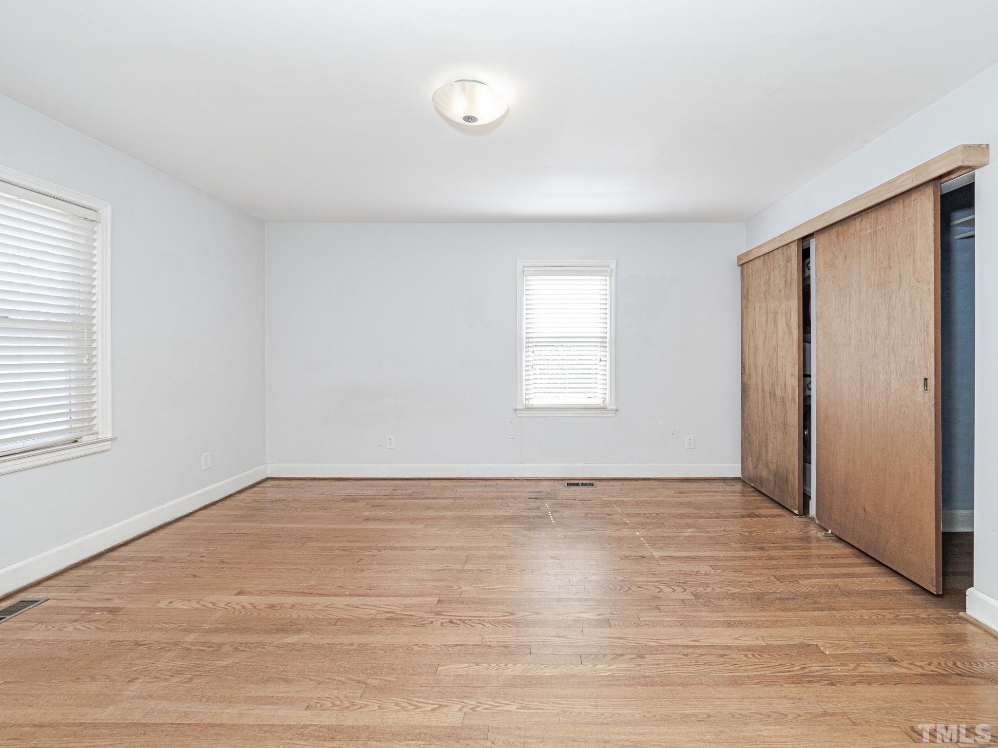 716 Hamilton Road Raleigh, NC 27604 - Photo 5 of 15 an empty room with wooden floor and windows