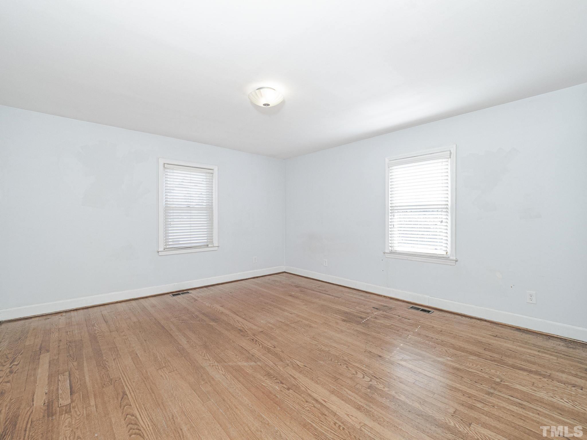 716 Hamilton Road Raleigh, NC 27604 - Photo 6 of 15 an empty room with wooden floor and windows
