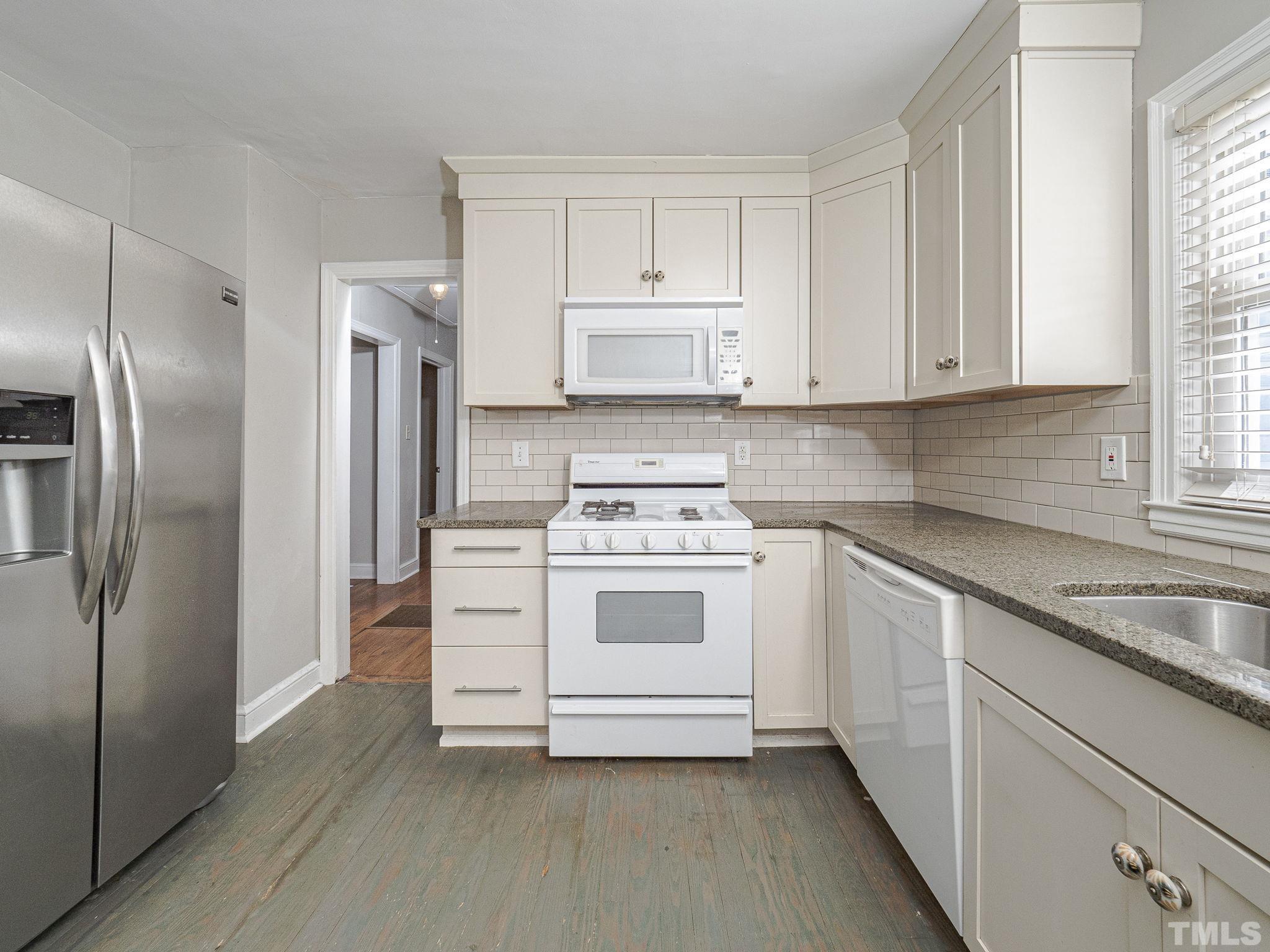 716 Hamilton Road Raleigh, NC 27604 - Photo 10 of 15 a kitchen with white cabinets and stainless steel appliances