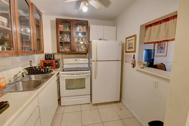 a kitchen with a refrigerator sink and cabinets