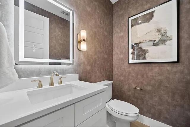 a bathroom with a toilet a sink and mirror