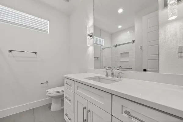 a bathroom with a sink a toilet and a mirror
