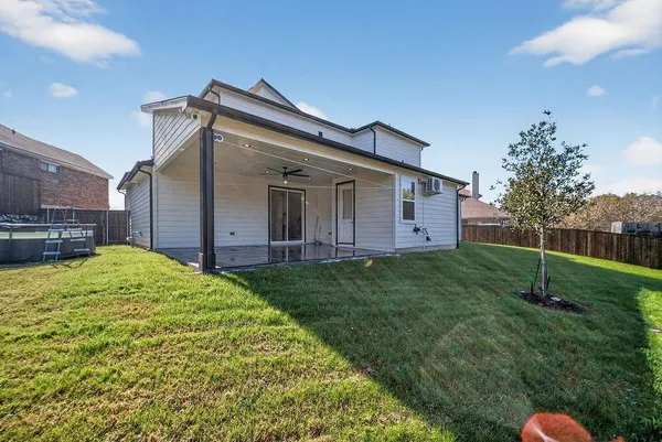 a backyard of a house with plants and wooden fence