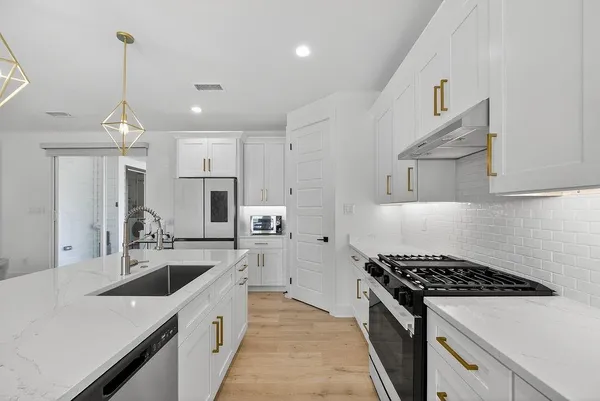 a kitchen with stainless steel appliances a sink a stove and a refrigerator