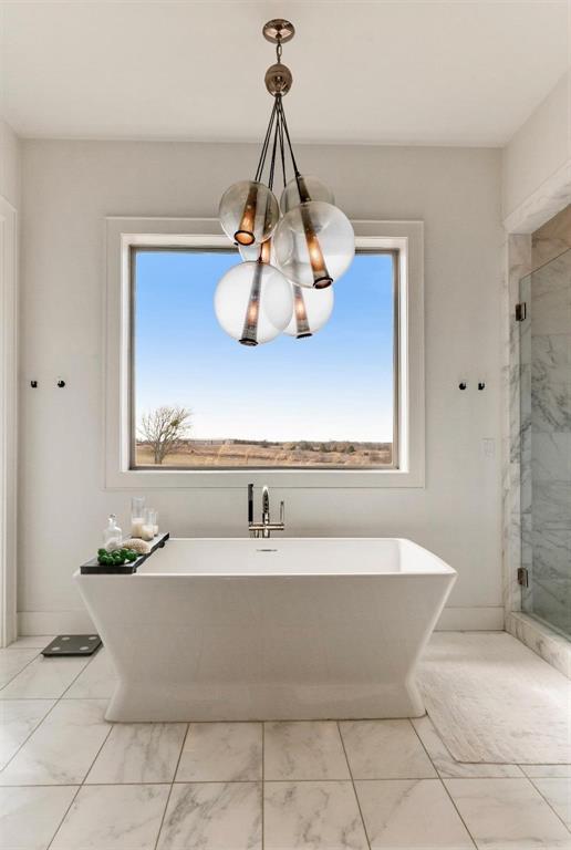 2106 County Road Paris, TX 75462 - Photo 18 of 40 a bathroom with a bathtub and chandelier