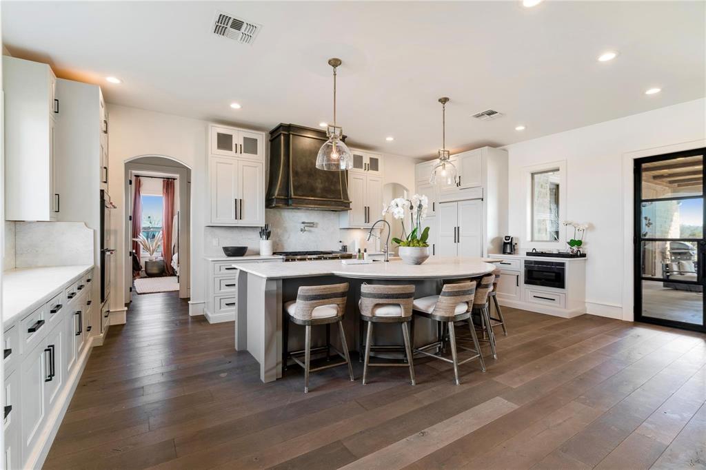 2106 County Road Paris, TX 75462 - Photo 10 of 40 a large kitchen with stainless steel appliances microwave a dining table and chairs