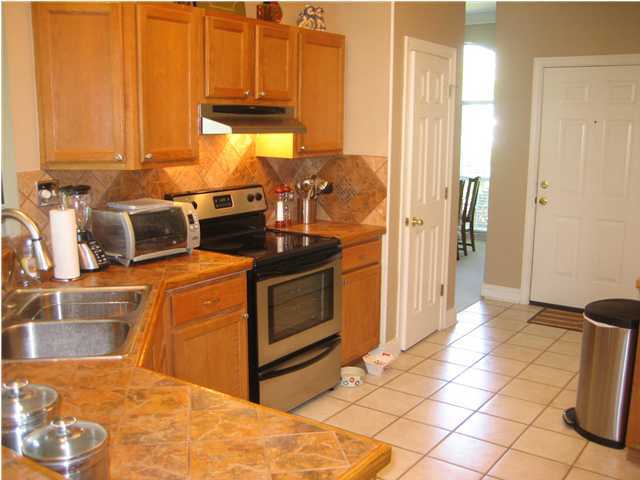 3851 Mesa Road Destin, FL 32541 - Photo 7 of 20 a kitchen with stainless steel appliances wooden cabinets and a stove top oven