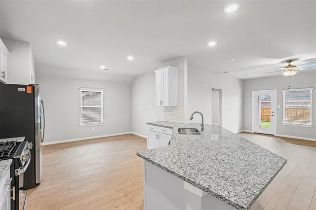 a kitchen with sink stove and refrigerator