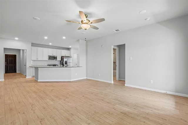 a view of a kitchen with a sink and wooden floor