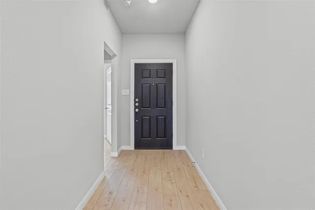 a view of a hallway with wooden floor