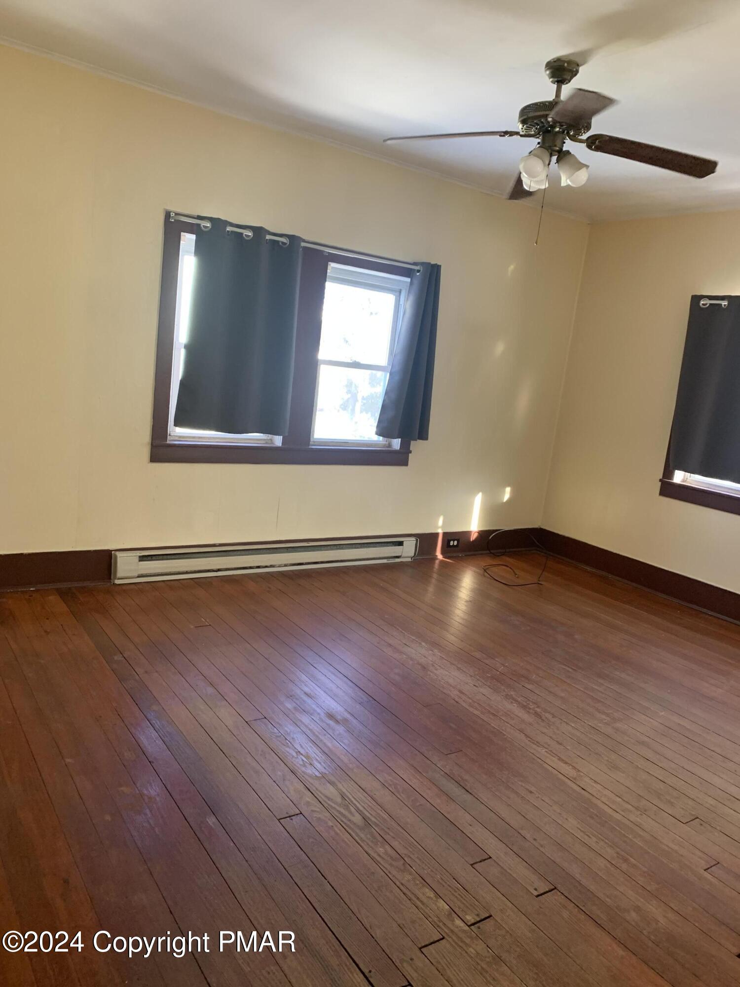 28 Reeder Street Mount Pocono, PA 18344 - Photo 9 of 17 an empty room with wooden floor and windows