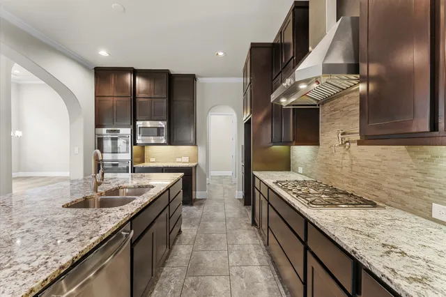 a kitchen with granite countertop a sink stove and cabinets