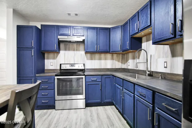 a kitchen with stainless steel appliances granite countertop wooden cabinets sink and stove