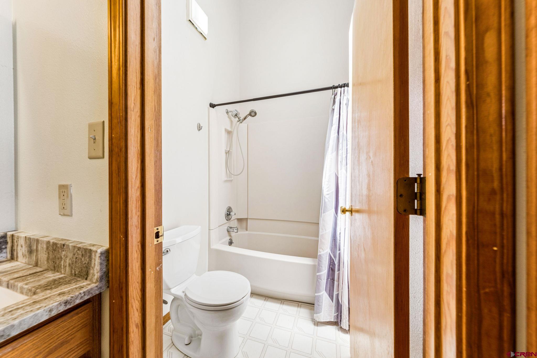 22480 Rd L Cortez, CO 81321 - Photo 20 of 44 a bathroom with a granite countertop toilet and a shower