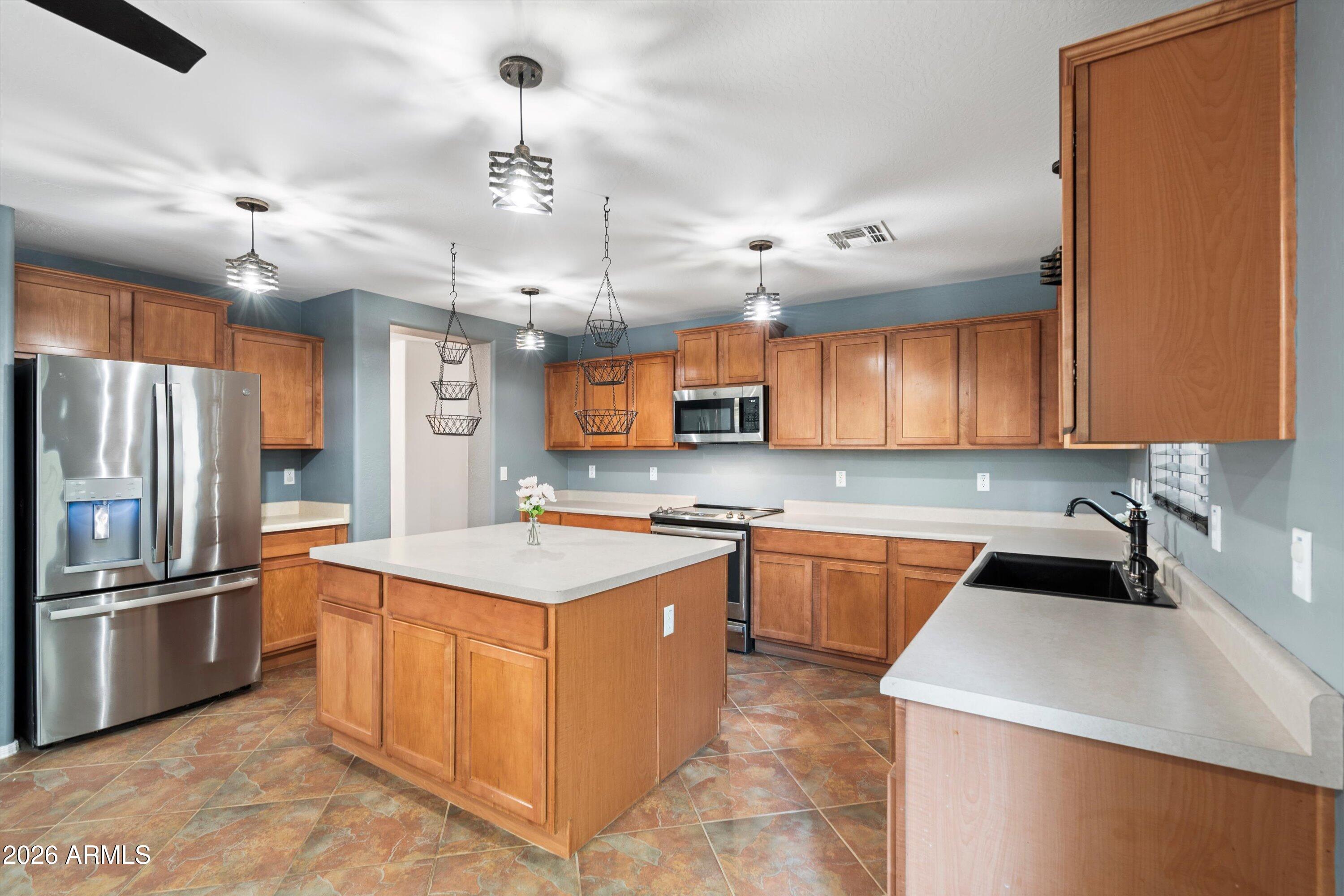 1231 West Ocotillo Street Coolidge, AZ 85128 - Photo 11 of 57 a kitchen with a sink a counter top space stainless steel appliances and cabinets