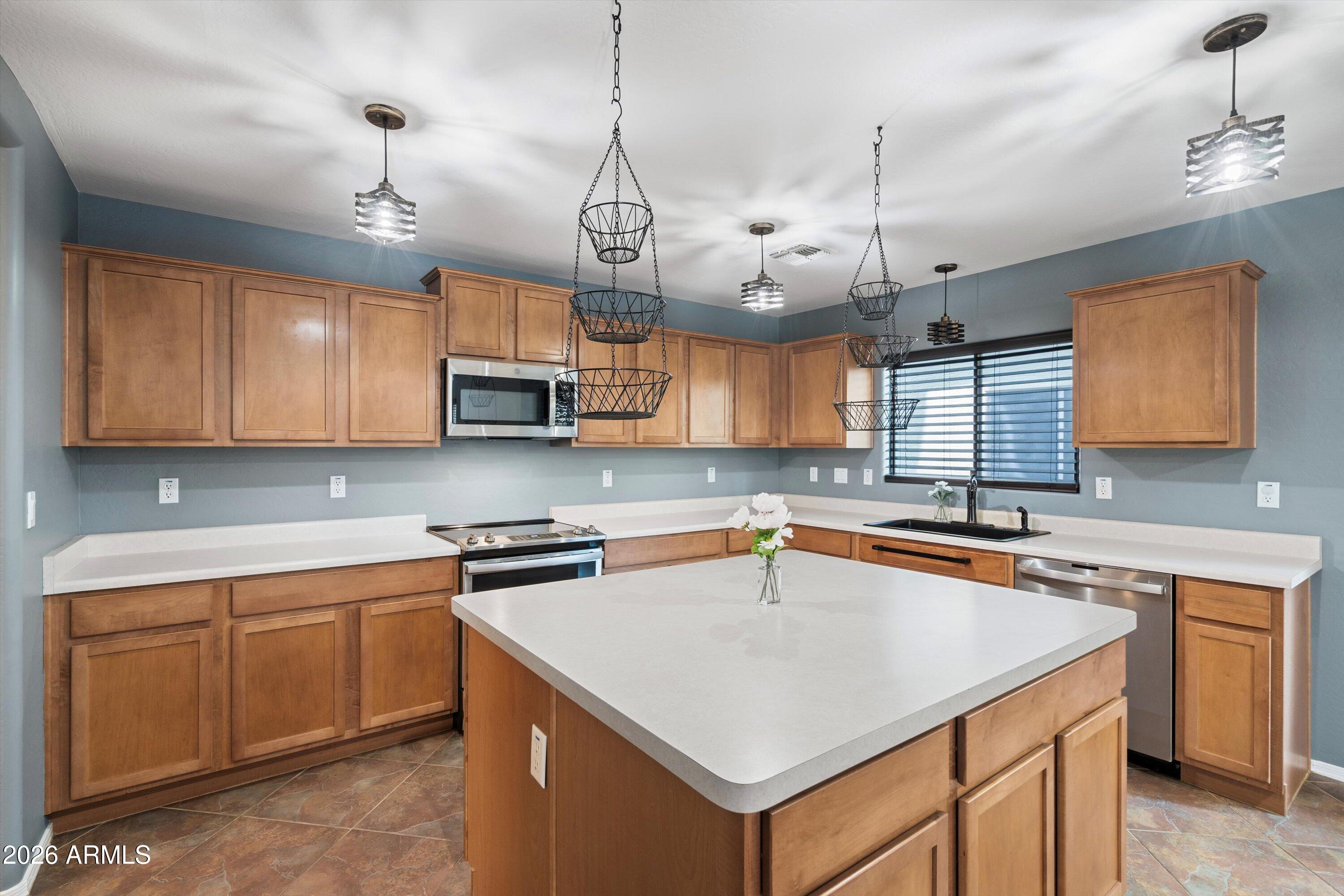 1231 West Ocotillo Street Coolidge, AZ 85128 - Photo 14 of 57 a kitchen with stainless steel appliances granite countertop a sink a stove and a microwave