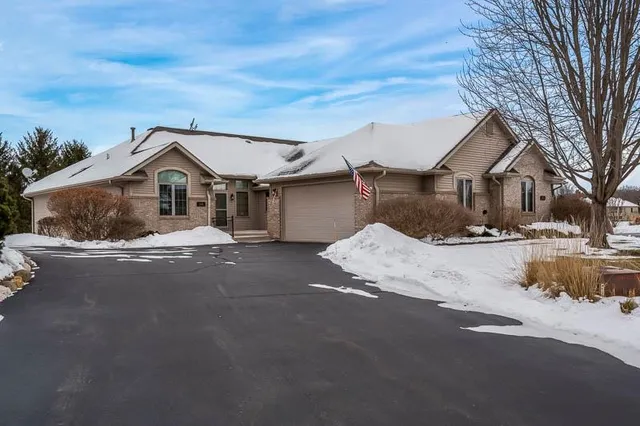a front view of a house with a yard covered in snow