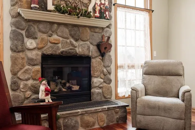 a living room with furniture a fireplace and a window