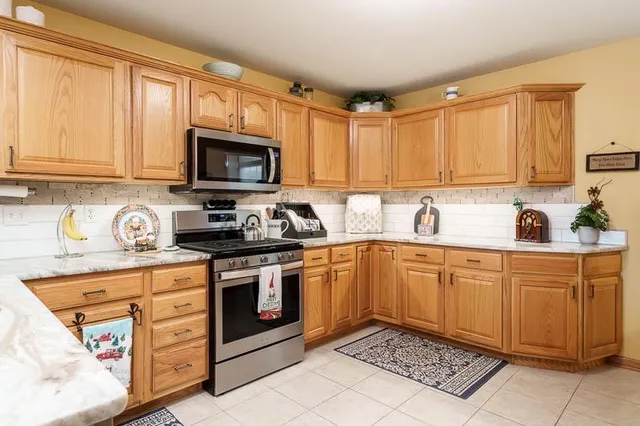 a kitchen with stainless steel appliances granite countertop a stove a sink and a microwave